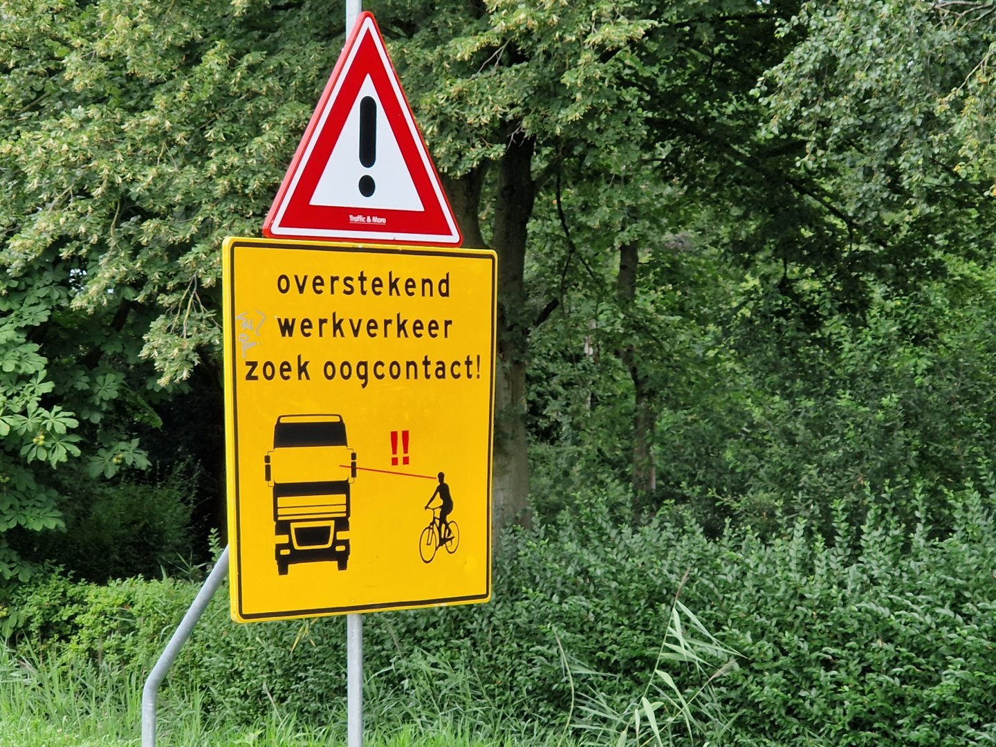 Waarschuwingsbord met de tekst 'Overstekend werkverkeer. Zoek oogcontact!'