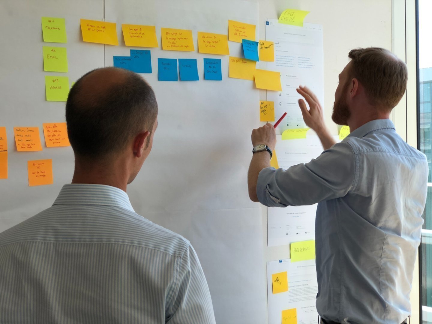 Twee mensen voor een bord met allemaal post-its.