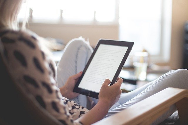 Een vrouw leest een tekst op een e-reader.